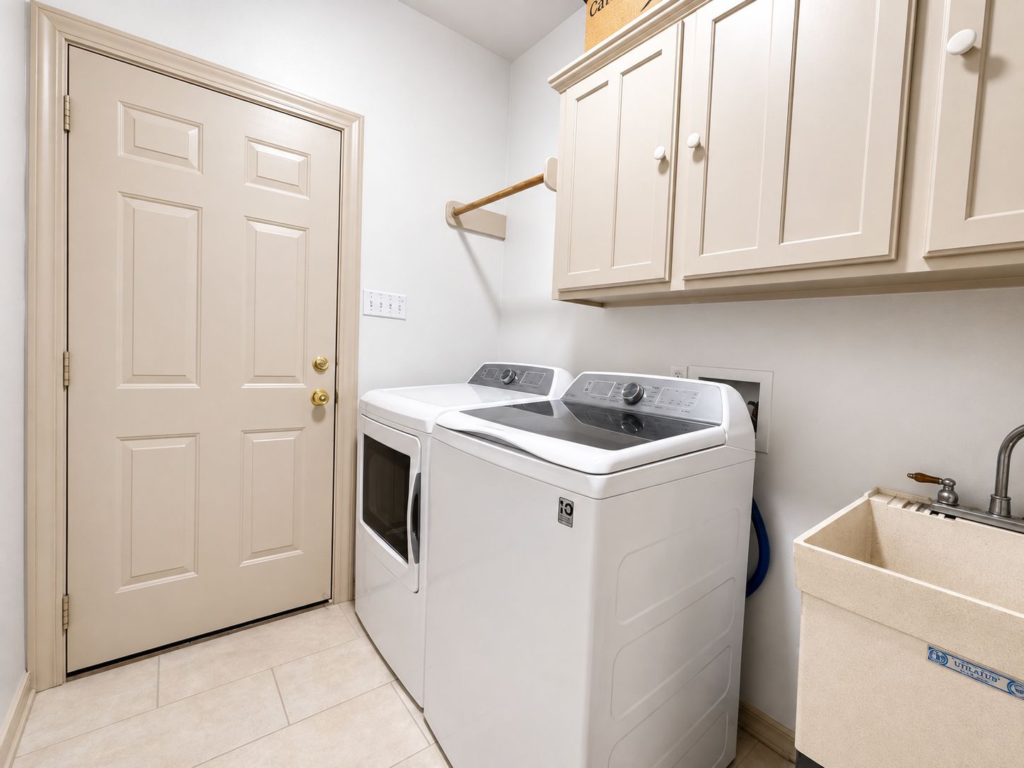 Well appointed utility room with abundant cabinet storage and utility sink