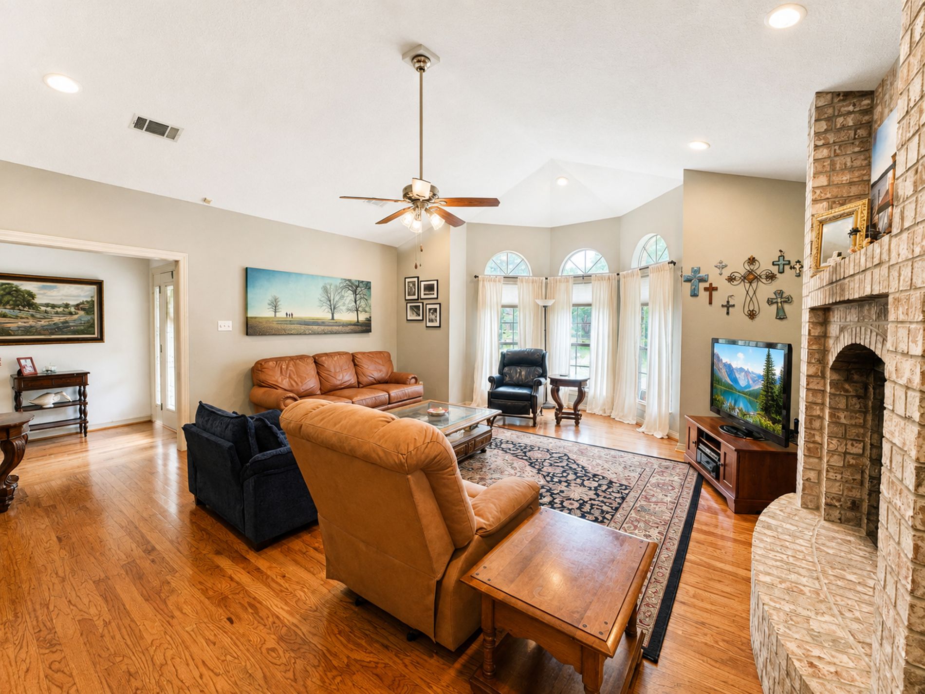 Living room filled with natural light from bay windows, anchored by a beautiful fireplace.